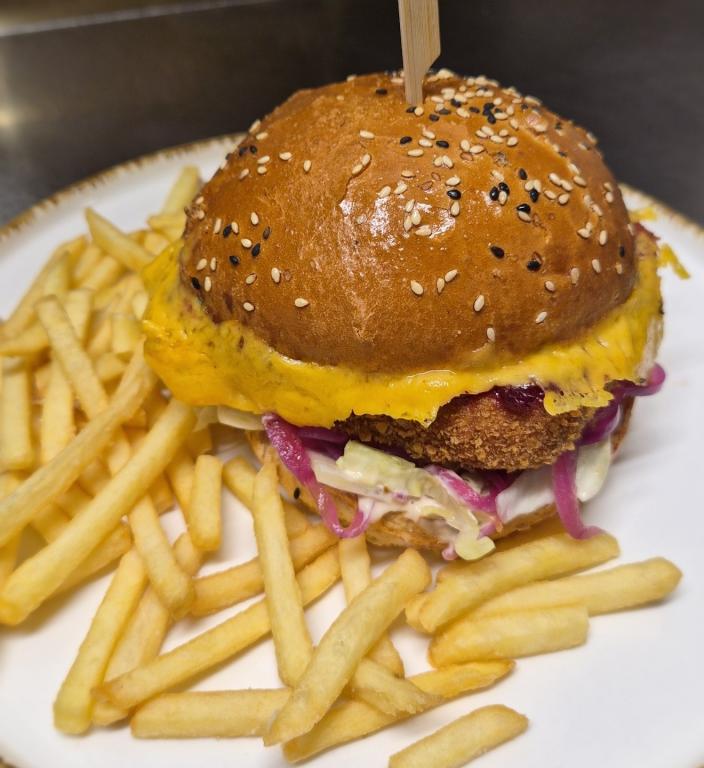 Smažák Burger - Bulka z pekařství Křížák,150g gouda, brusinky, nakládaná cibulka, chedarový chips, ledový salát, dresing  215,-